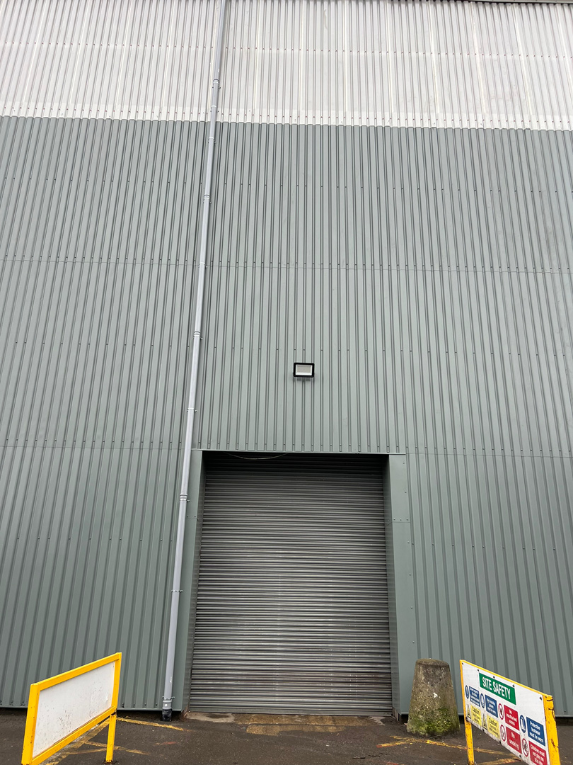 Green cladding on warehouse near roller door