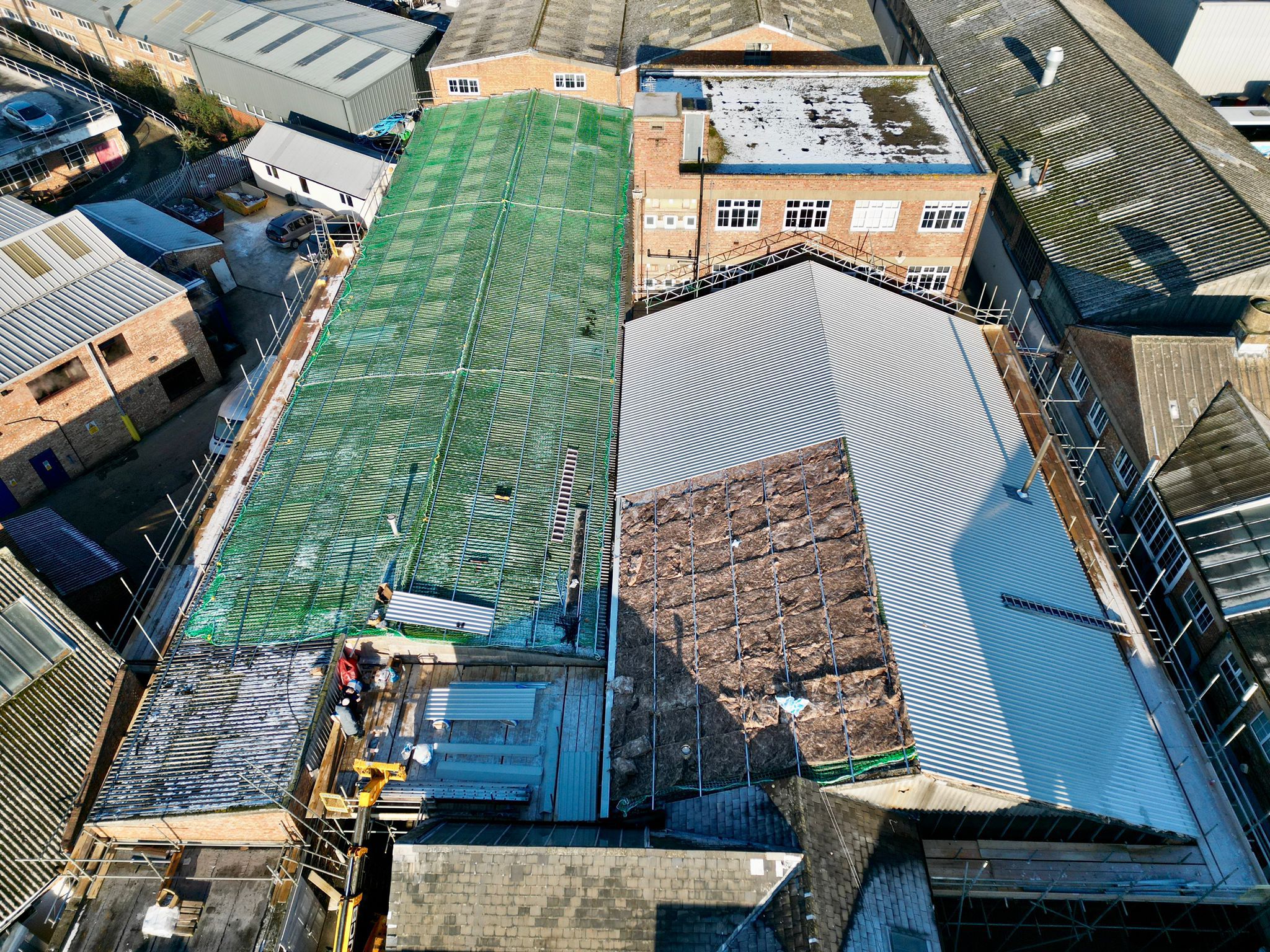 aerial image of of large warehouse roofing being completed
